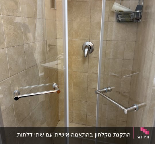 מקלחון עם דלתות זכוכית ומדף מתכת